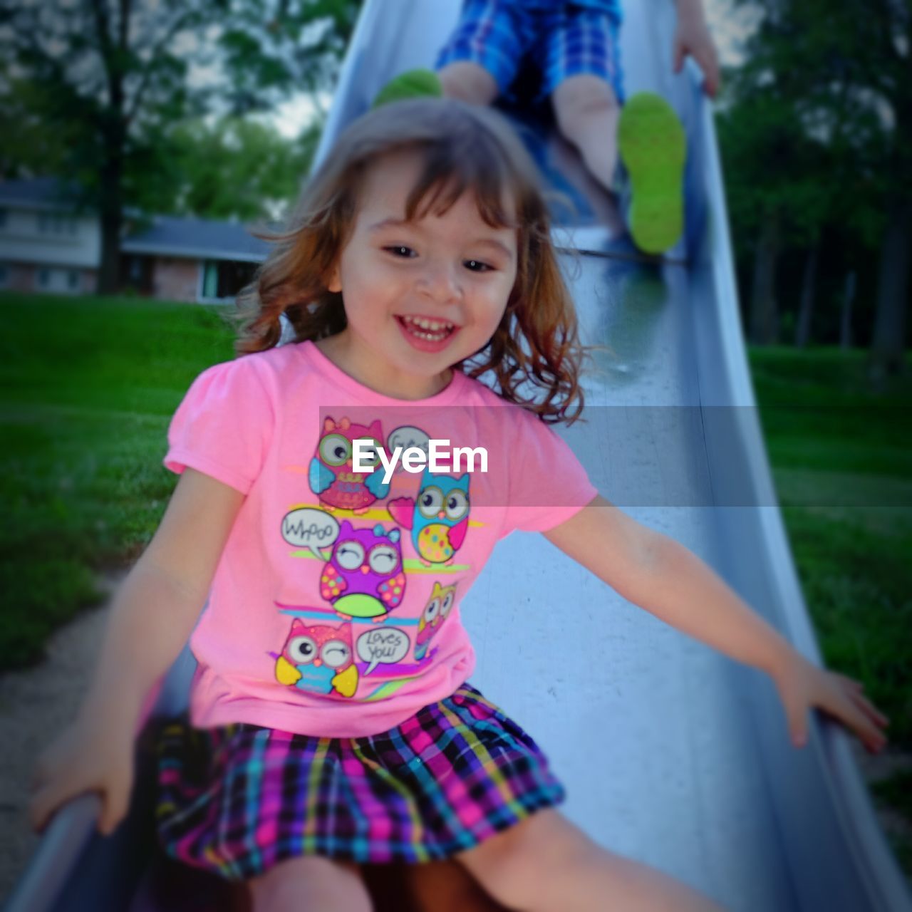 Happy cute girl enjoying slide in park