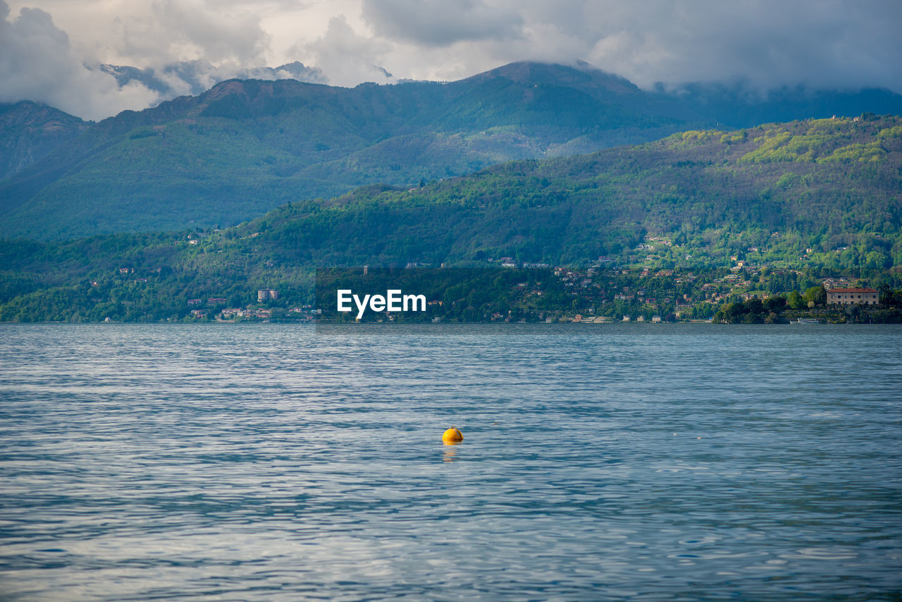 Scenic view of sea and mountains against sky