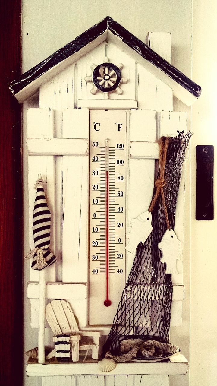 Thermometer with miniature parasol and chair at home