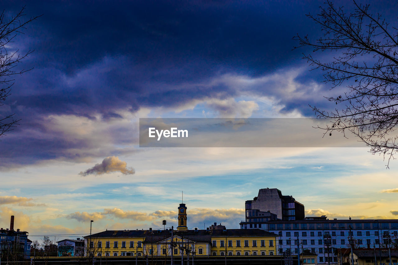 BUILDINGS AGAINST CLOUDY SKY