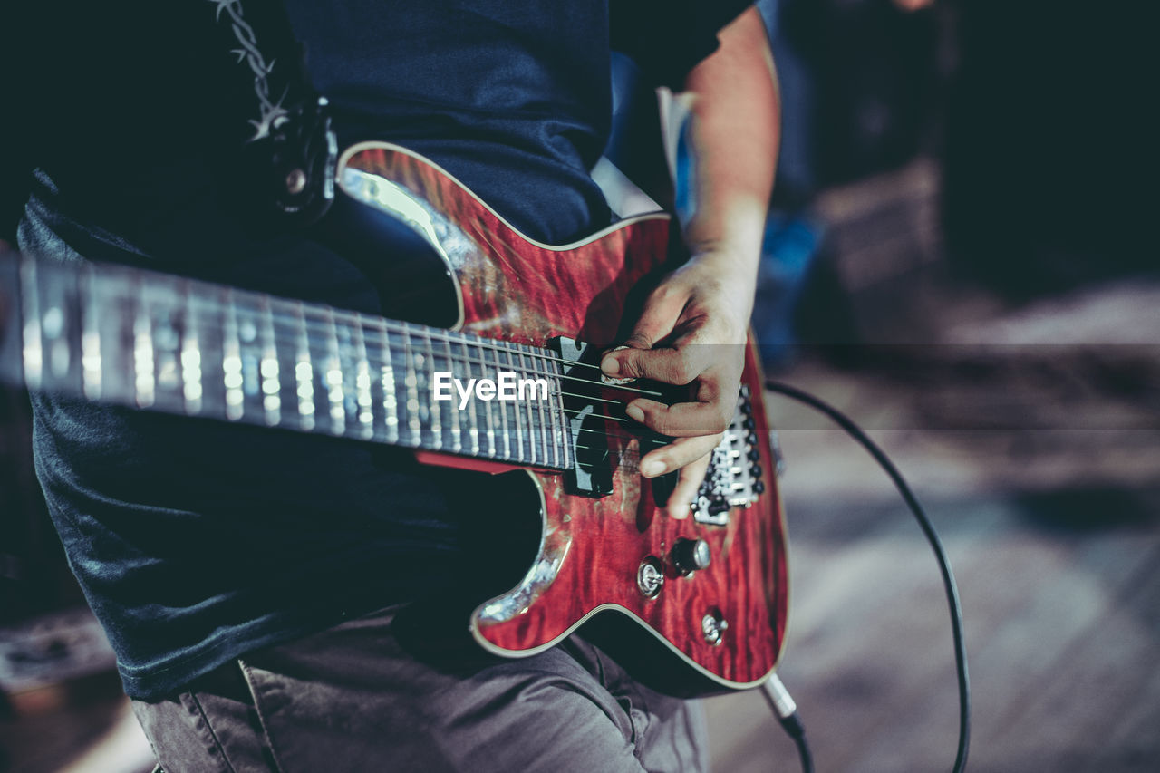 Close-up of man playing guitar