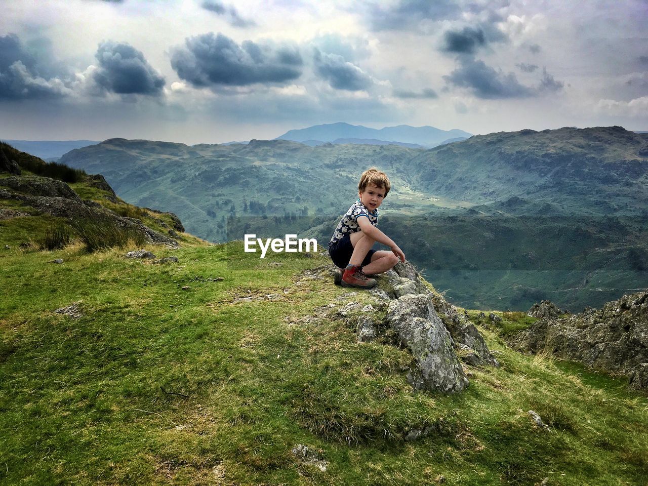 View of boy sitting on mountain
