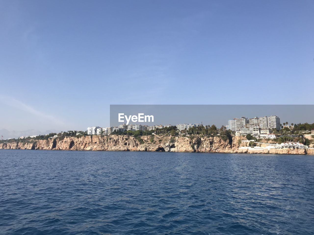 SEA BY BUILDINGS AGAINST BLUE SKY