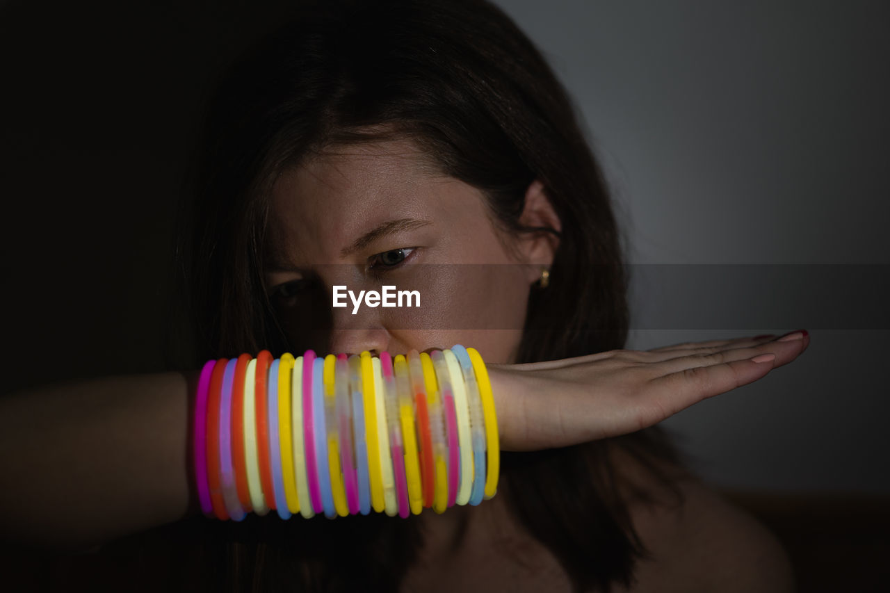Close-up portrait of girl with neon bracelets
