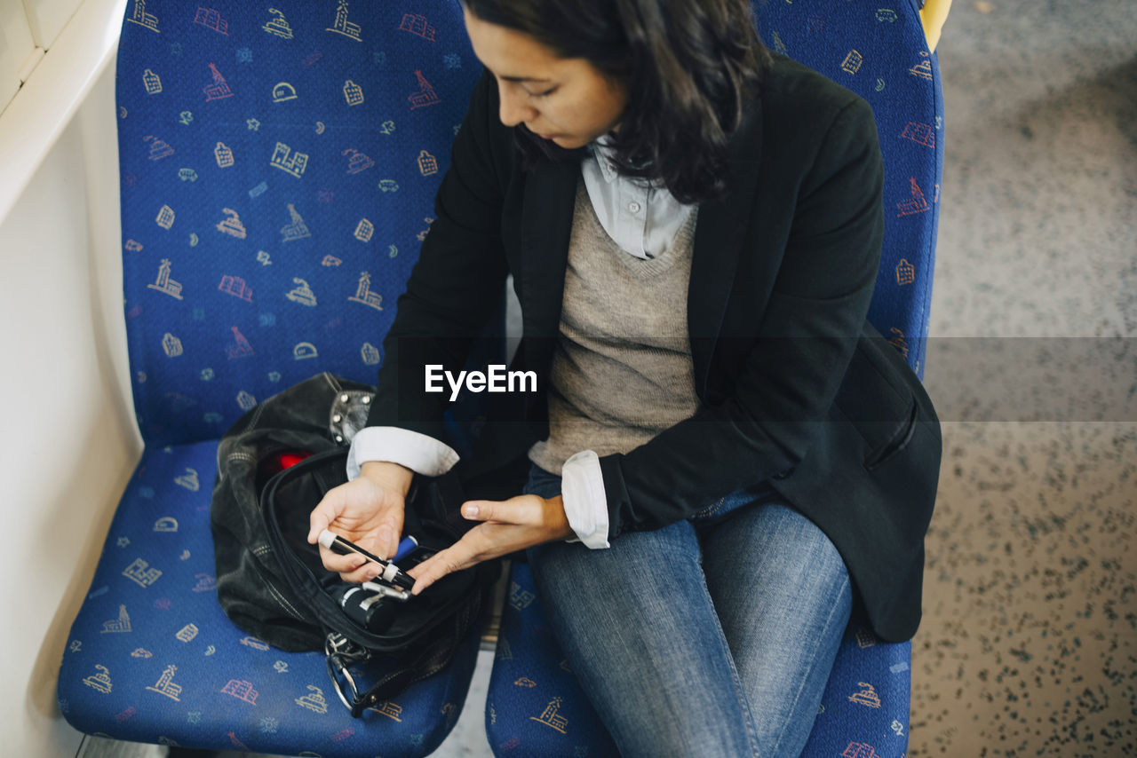 Woman doing blood test while traveling in train