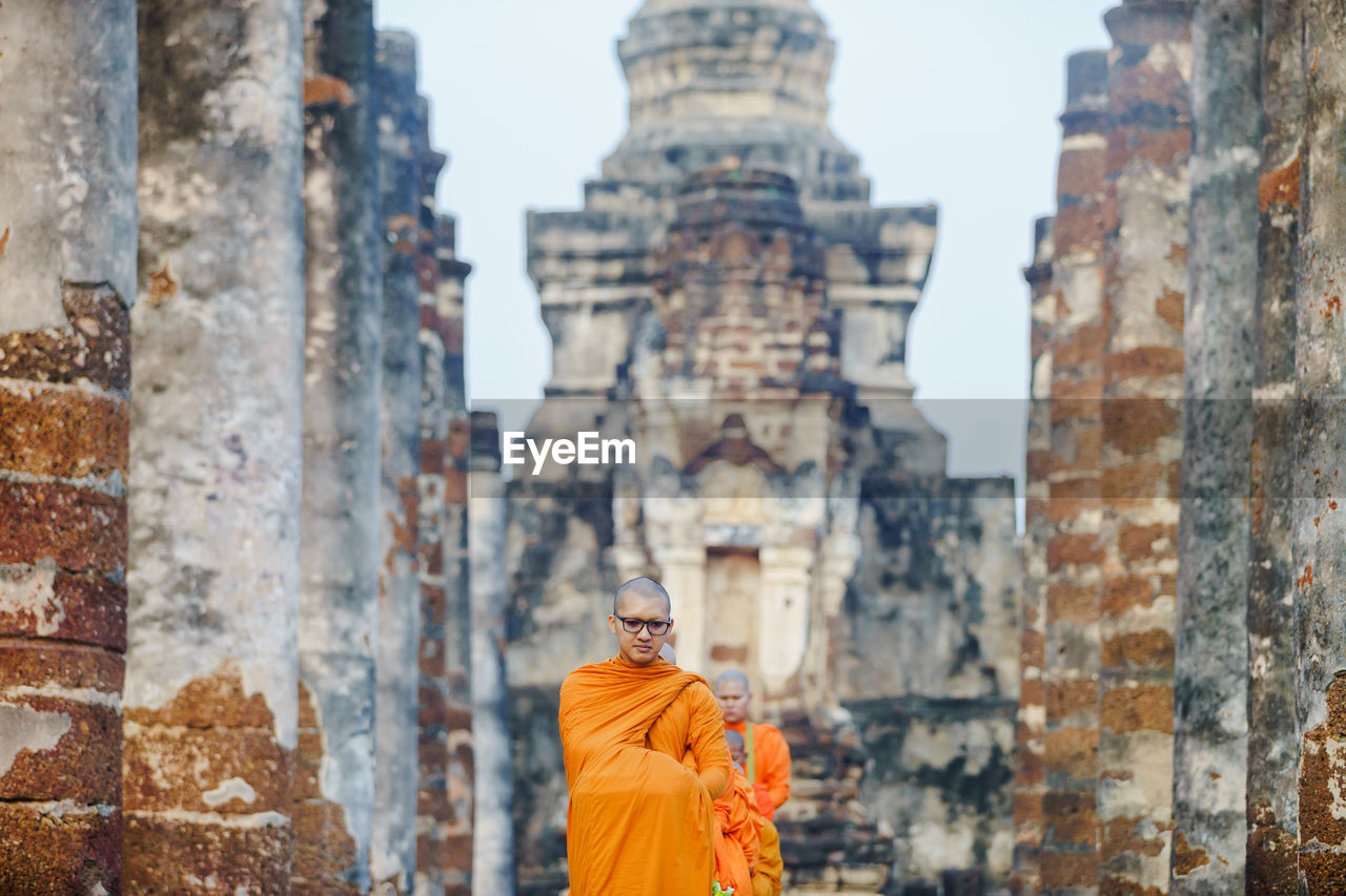 Monks wearing traditional clothing standing in row at temple