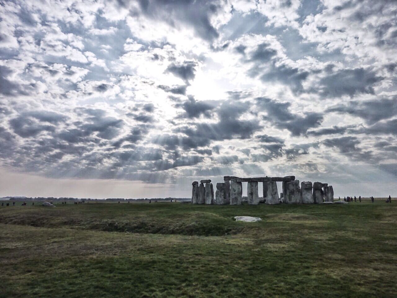 Stonehenge on landscape against cloudy sky