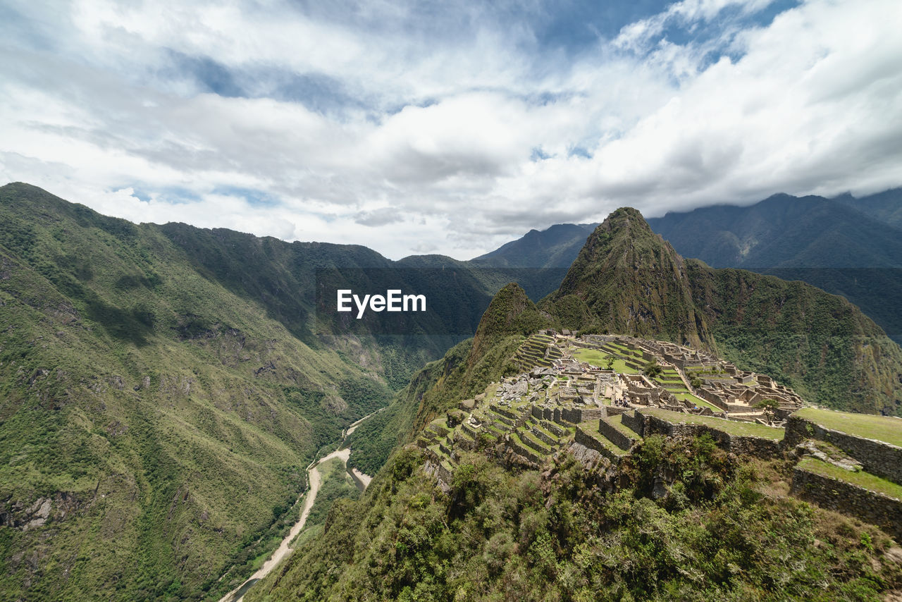 PANORAMIC VIEW OF MOUNTAIN RANGE AGAINST CLOUDY SKY