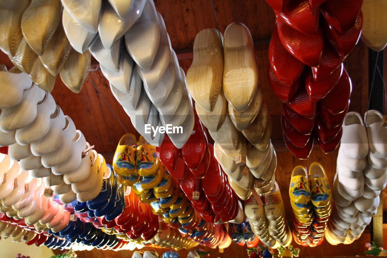 Low angle view of clogs hanging on ceiling in shop