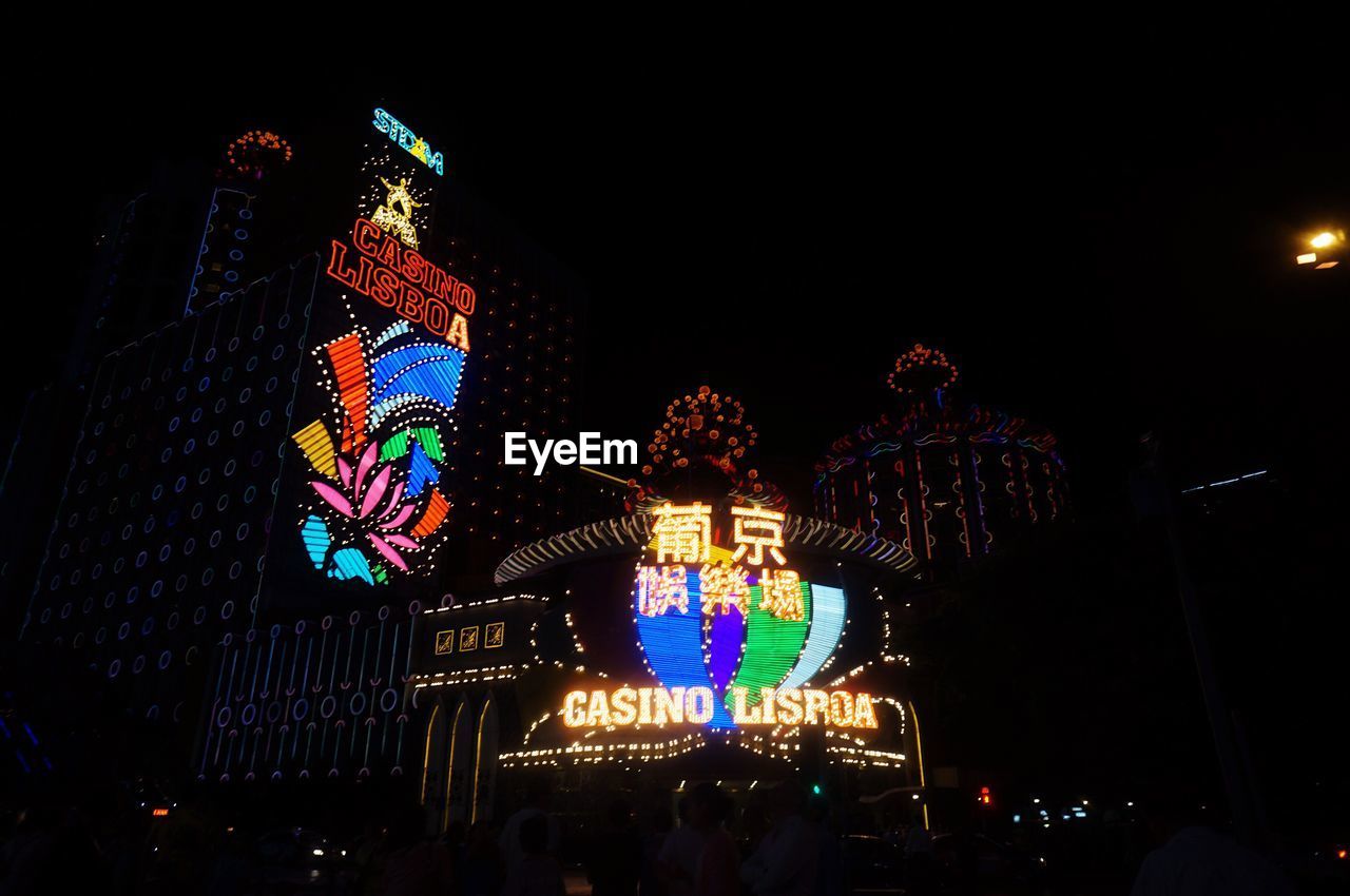 LOW ANGLE VIEW OF ILLUMINATED CHRISTMAS TREE AT NIGHT