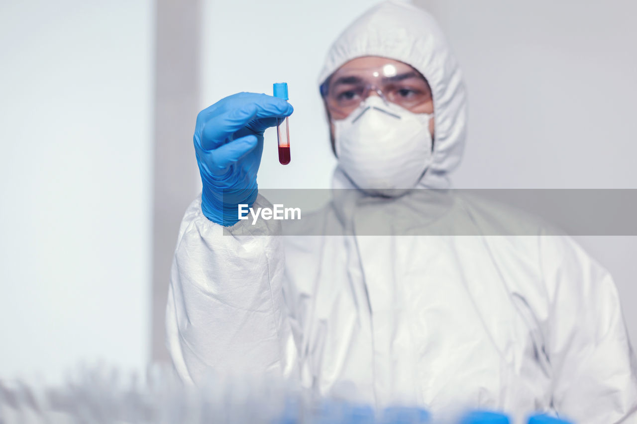 portrait of female doctor wearing protective mask against wall