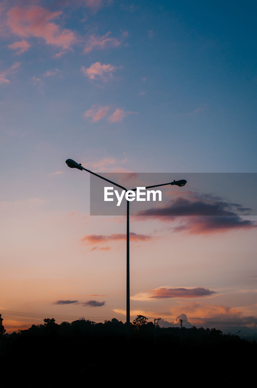 LOW ANGLE VIEW OF STREET LIGHT AGAINST SKY DURING SUNSET