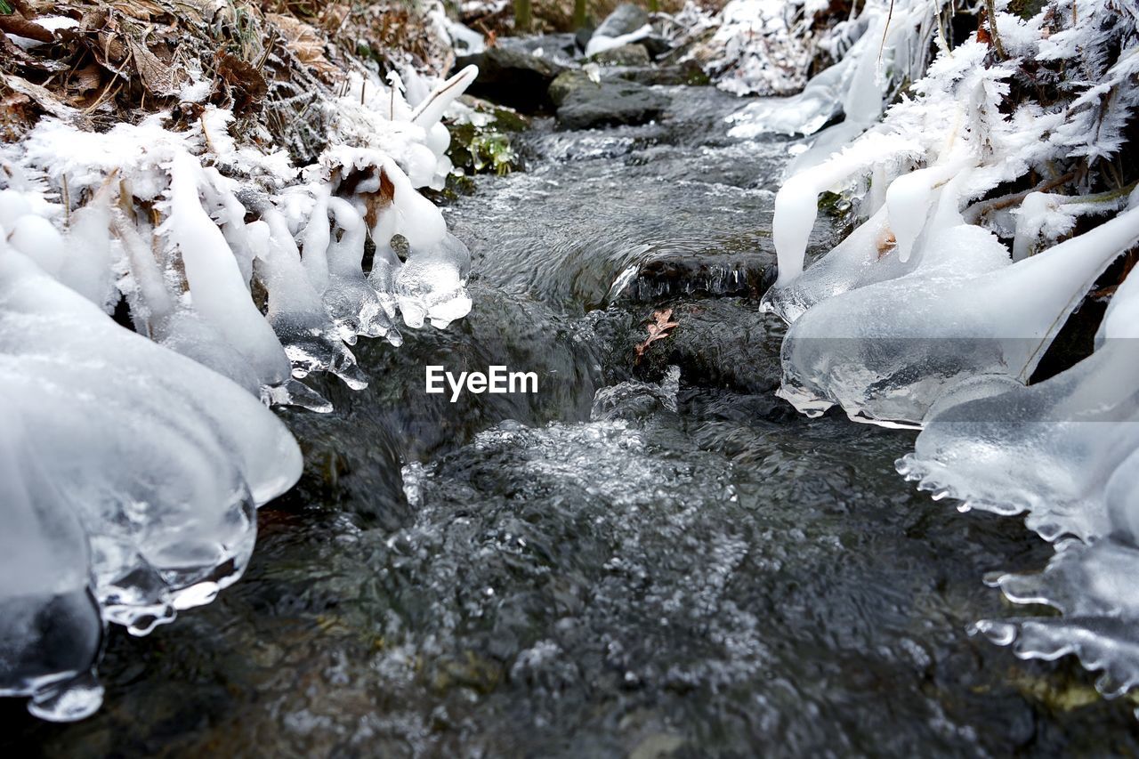 Frozen river amidst rocks