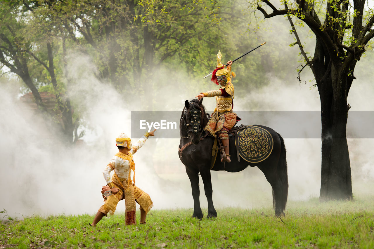 horse, animal, plant, mammal, animal themes, adult, nature, domestic animals, men, animal wildlife, tree, activity, grass, full length, clothing, livestock, land, riding, outdoors, screenshot, fog, motion, two people, one animal, horseback riding, pet, person, working animal, traditional clothing, landscape, weapon, forest, rural scene, occupation
