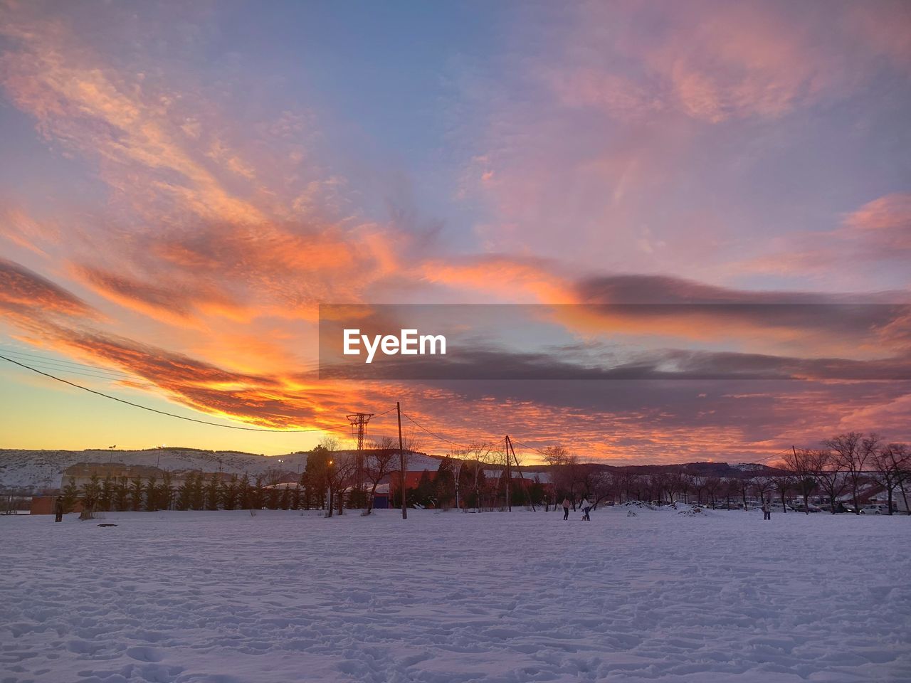 SNOW COVERED FIELD AGAINST SKY DURING SUNSET