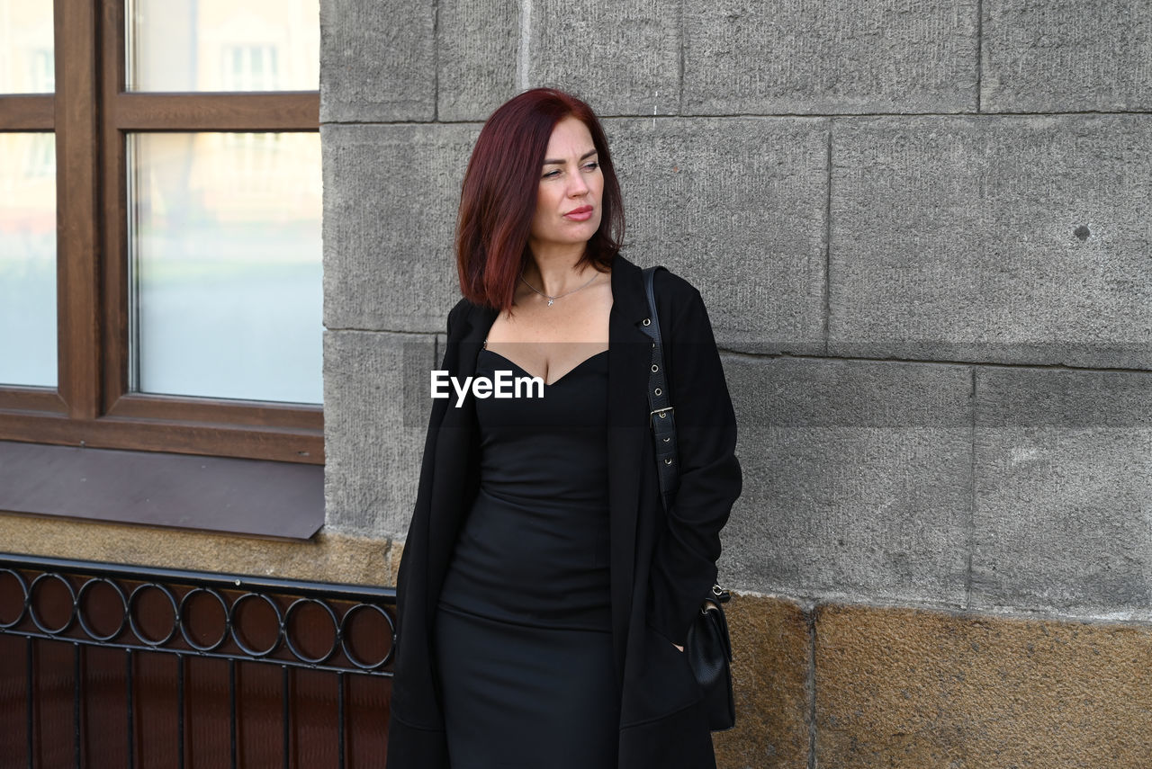 portrait of woman standing against wall