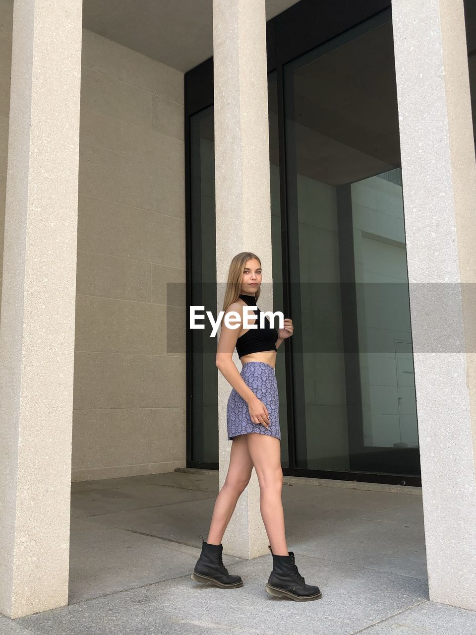 Full length portrait of teenage girl standing against building