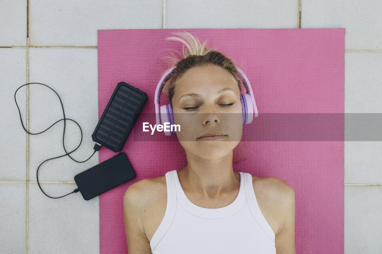 Woman with closed eyes listening to music with headphones and relaxing