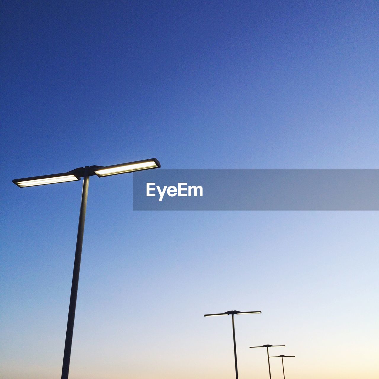 Low angle view of street light against clear blue sky