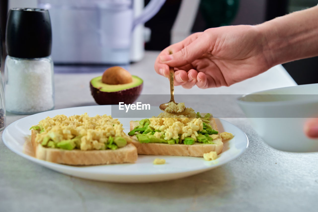 Woman preparing toasts with avocado, healthy food and dieting concept, organic product