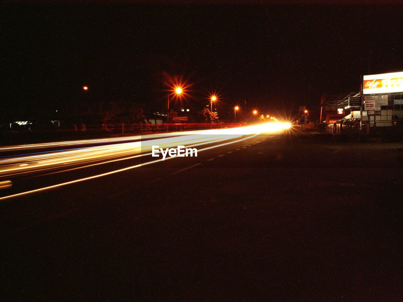 LIGHT TRAILS ON ROAD AT NIGHT