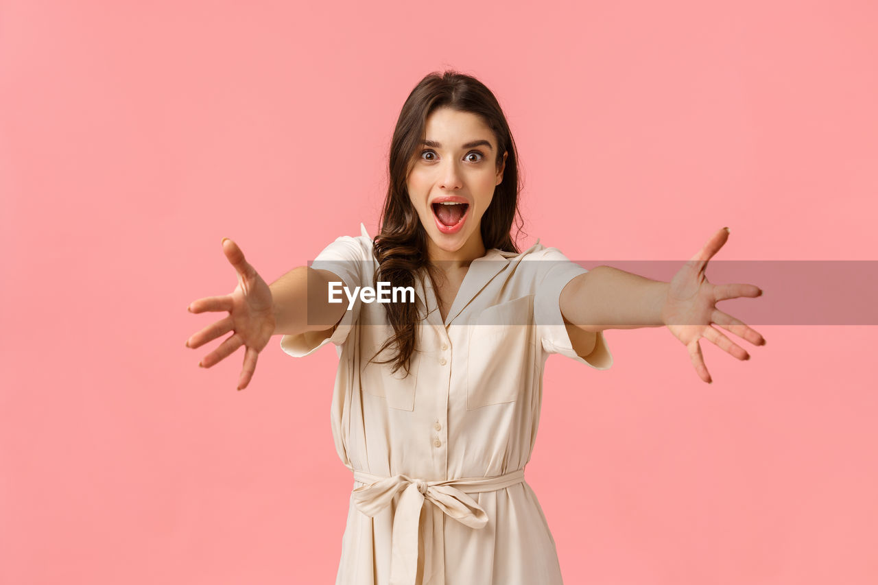 PORTRAIT OF A YOUNG WOMAN AGAINST COLORED BACKGROUND