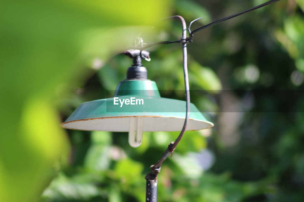 Close-up of electric lamp hanging on rope in yard