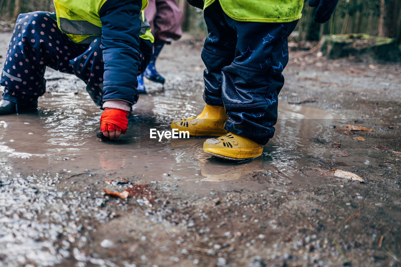 Lower section of children playing in puddle