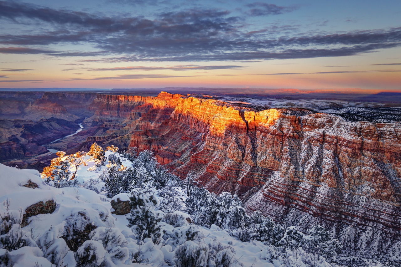 Scenic view of mountains against cloudy sky during sunset