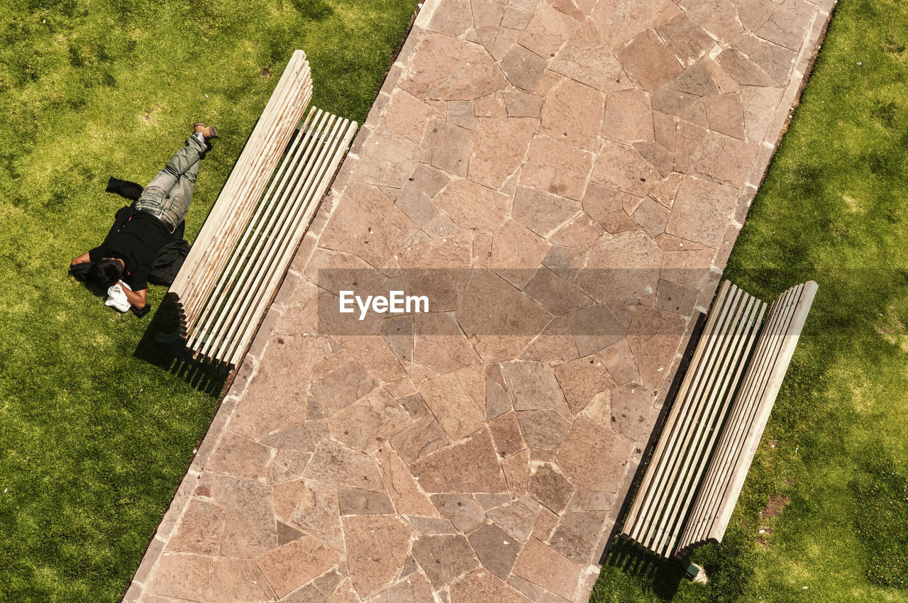 High angle view of man lying on grassy field at park