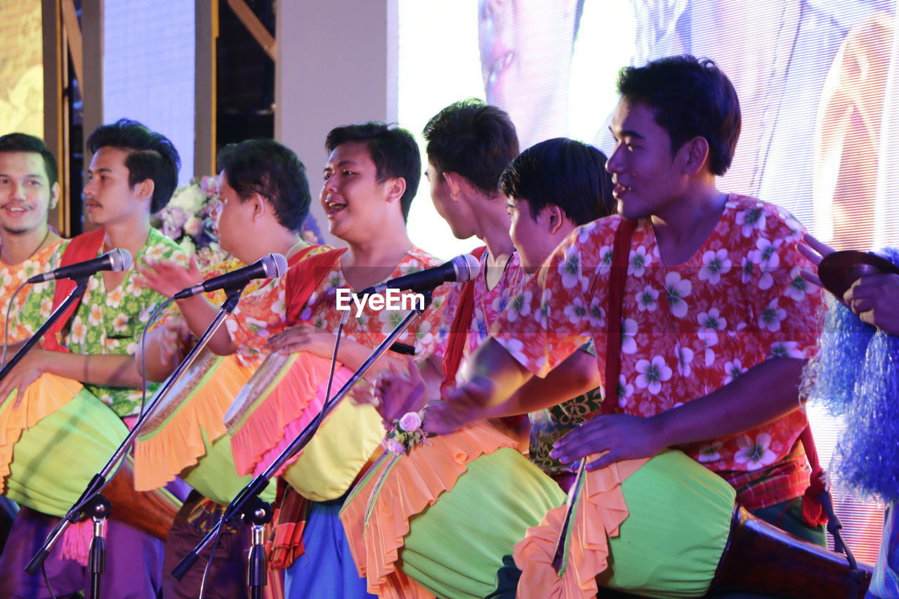 GROUP OF PEOPLE DANCING IN MUSIC CONCERT