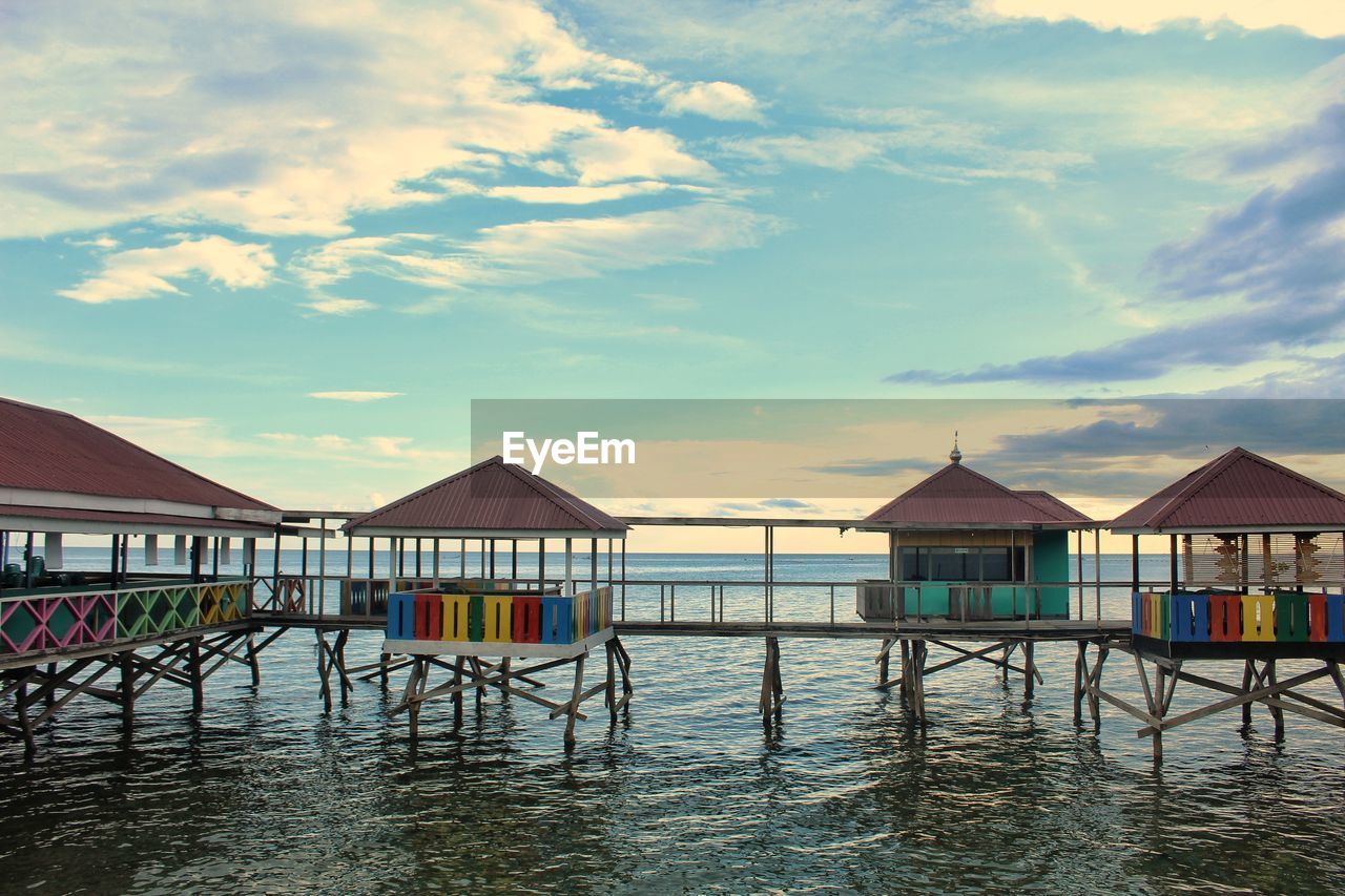 Houses on beach by building against sky