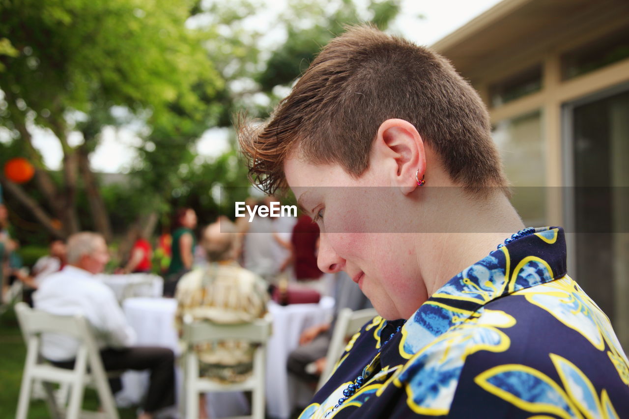 Side view of short haired woman at backyard