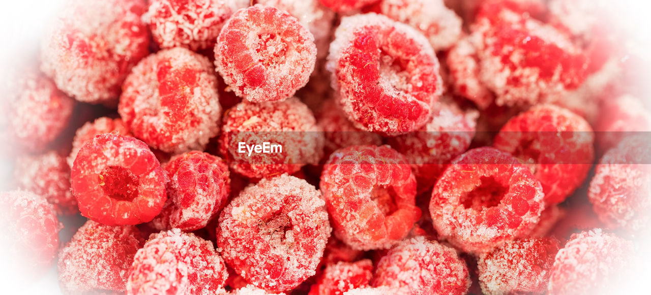 Frozen organic raspberry in white frosty frame. frozen berries retain all vitamins. 