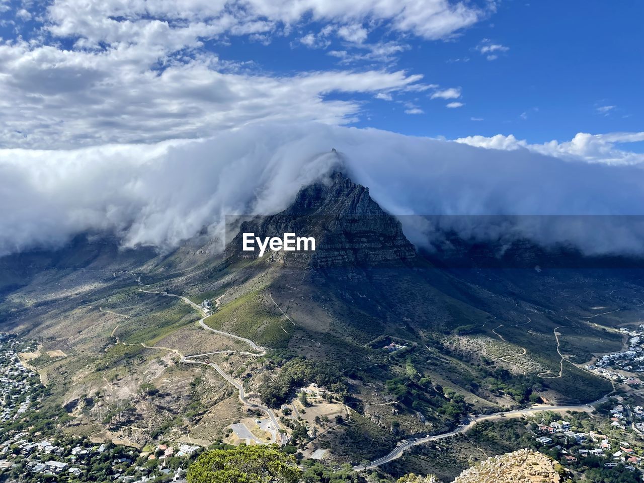 Table mountain under tablecloth clouds as seen from lionshead in cape town, south africa