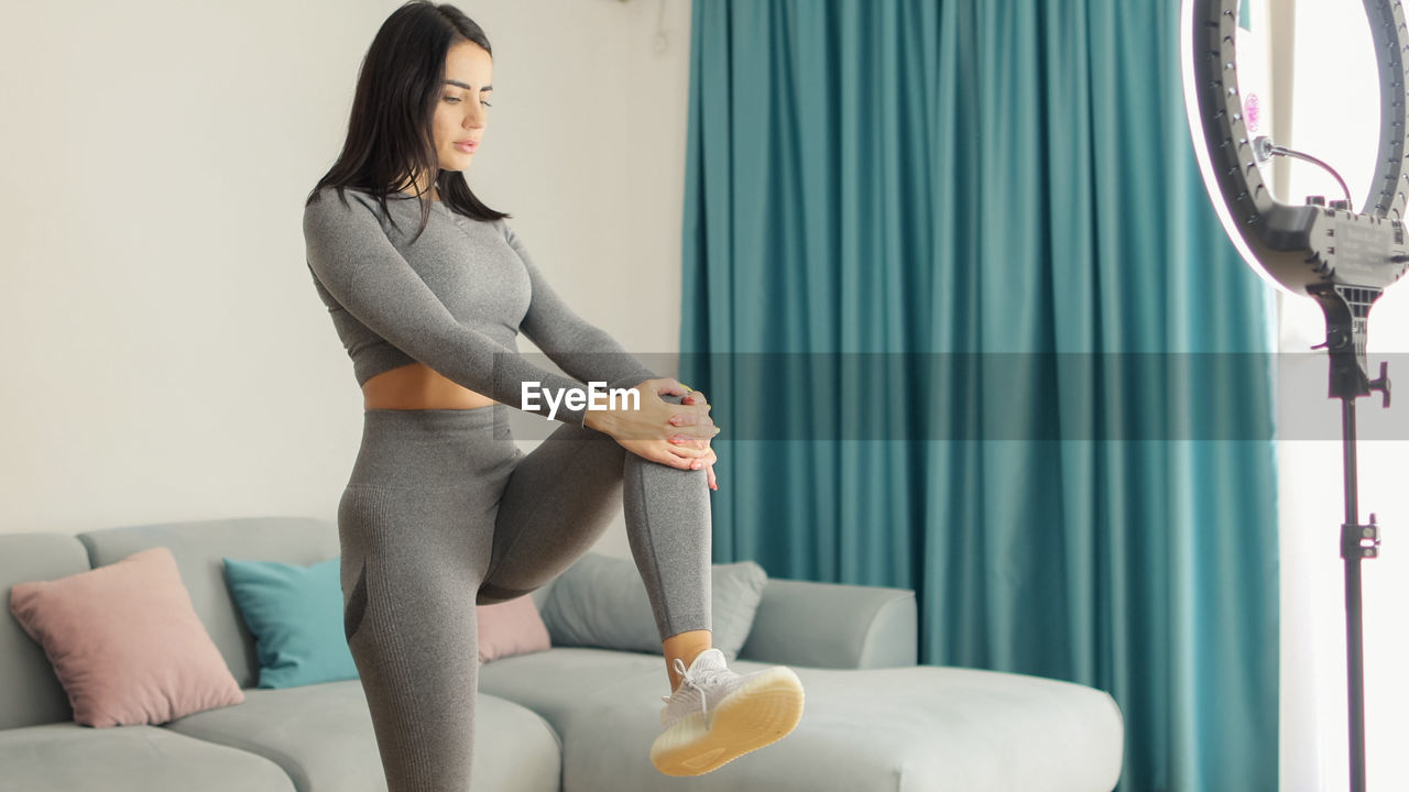 young woman sitting on bed