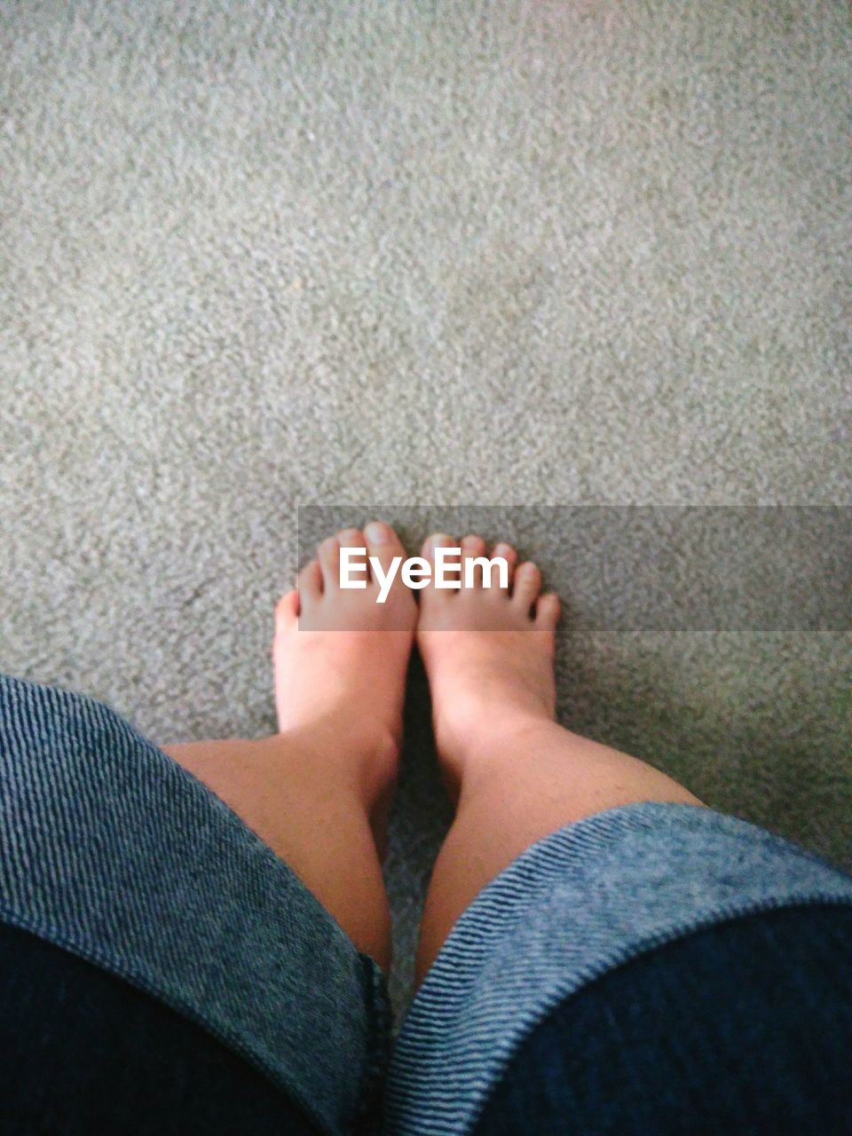 HIGH ANGLE VIEW OF YOUNG WOMAN FEET ON GROUND