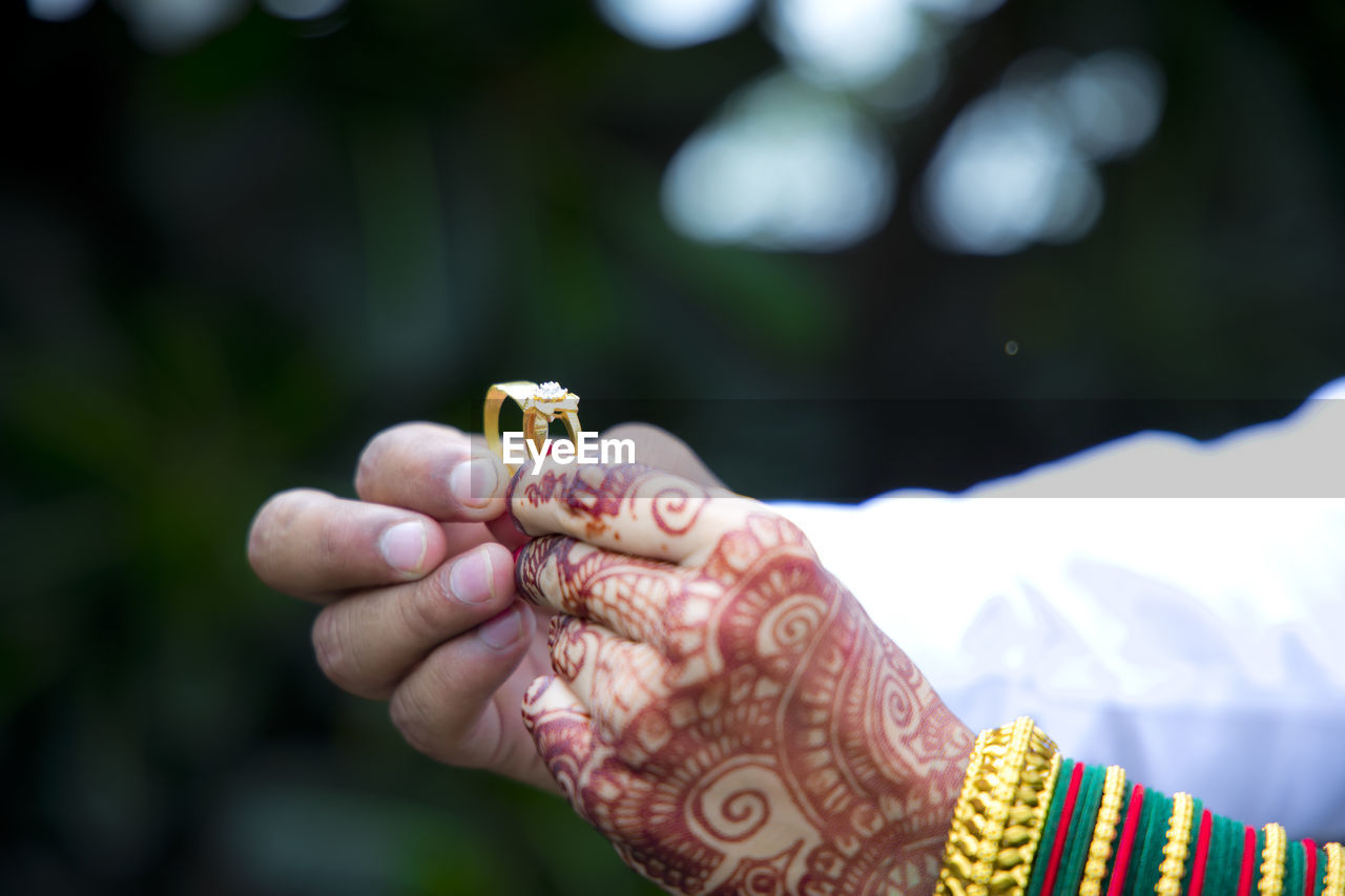 hand, ring, adult, jewelry, one person, focus on foreground, life events, wedding, finger, holding, celebration, women, bracelet, close-up, event, pattern, bride, yellow, newlywed, ceremony, wedding ceremony, henna, day, tradition, animal, outdoors