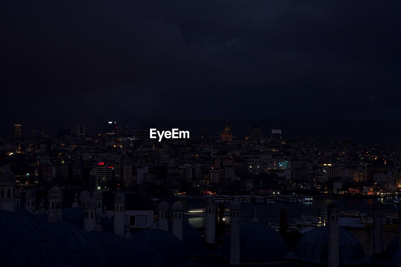 Illuminated cityscape against sky at night