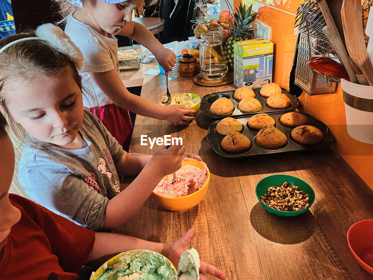 Group of children baking cupcakes, preparing ingredients, toppings, sprinkles for decorating cookies