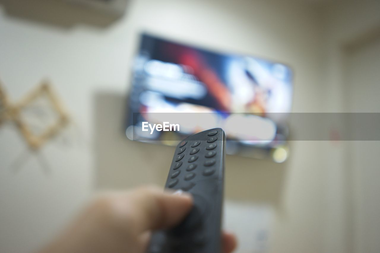 cropped hand of person holding remote control