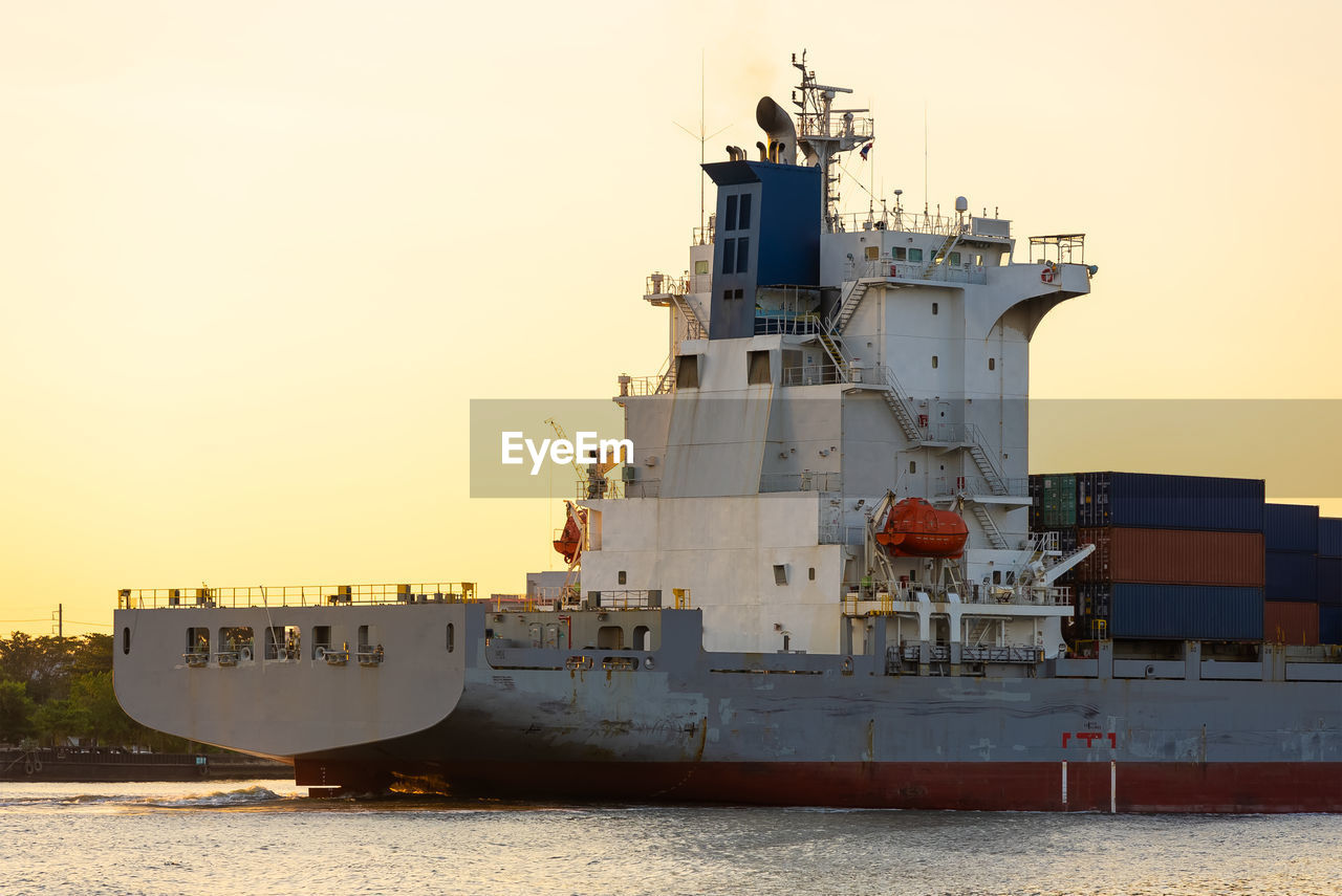 SHIP MOORED ON SHORE AGAINST SKY