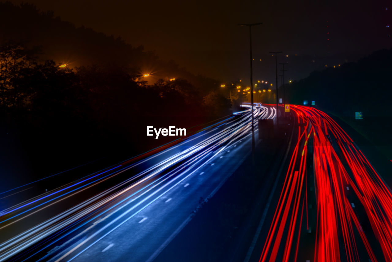 Illuminated light trails on highway at night