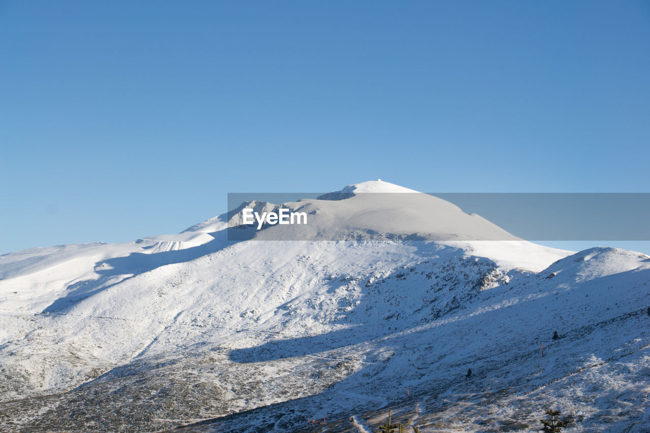 Scenic view of snowcapped mountains against clear blue sky