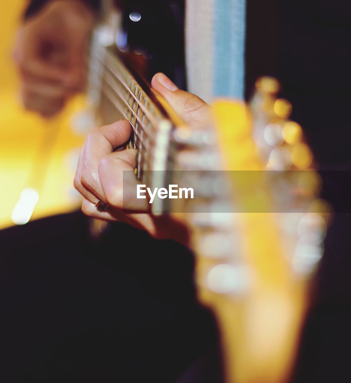 Cropped hand of man playing guitar