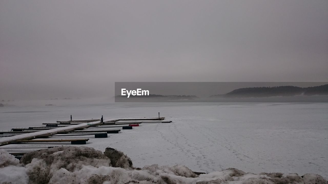 Scenic view of frozen lake against cloudy sky