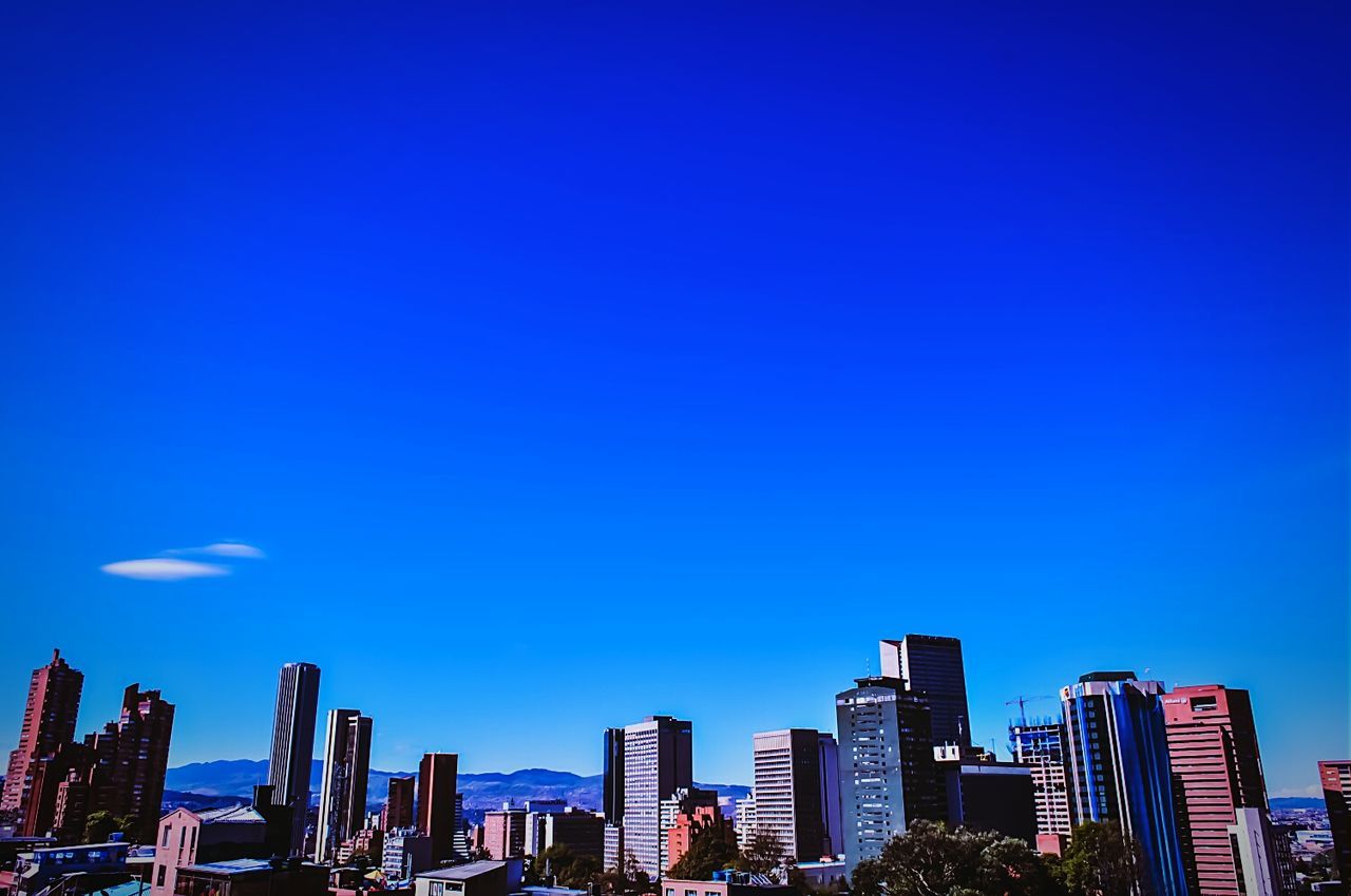 Low angle view of modern buildings against clear blue sky