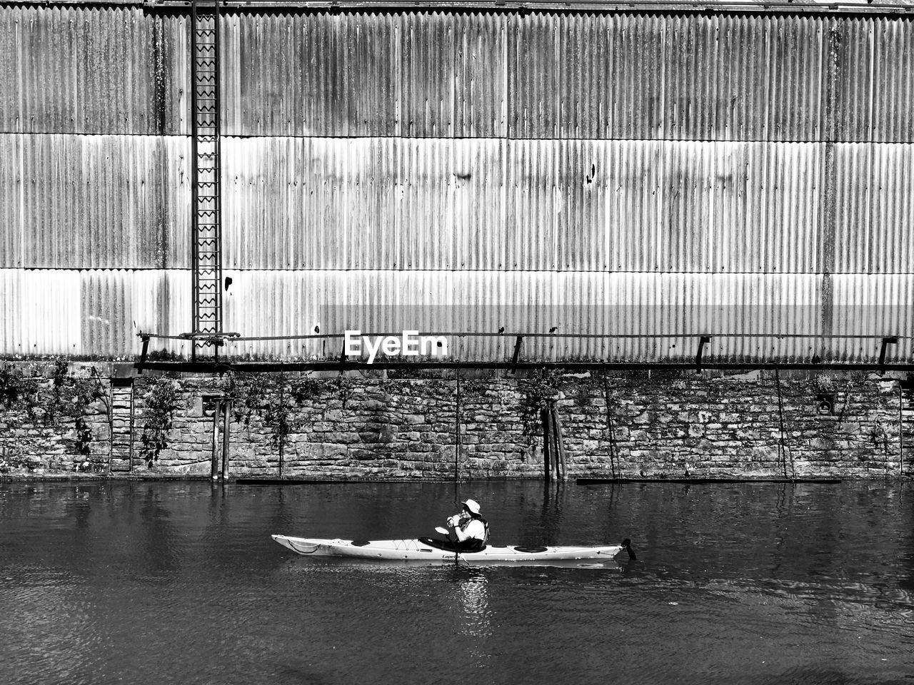 SIDE VIEW OF MAN ON BOAT IN RIVER