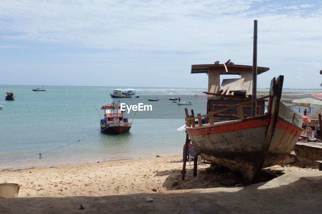 Scenic view of boats on beach with sea in background