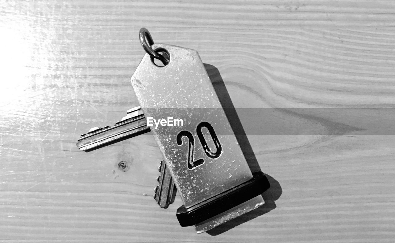 Close-up of number 20 on hotel key on wooden table